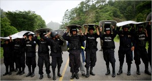 As rain fell, Honduran police officers blocked a road last week in Jacagalpa, near Nicaragua. (Rodrigo Abd/Associated Press) 