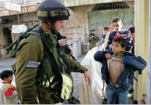 A soldier searches a child in the West Bank